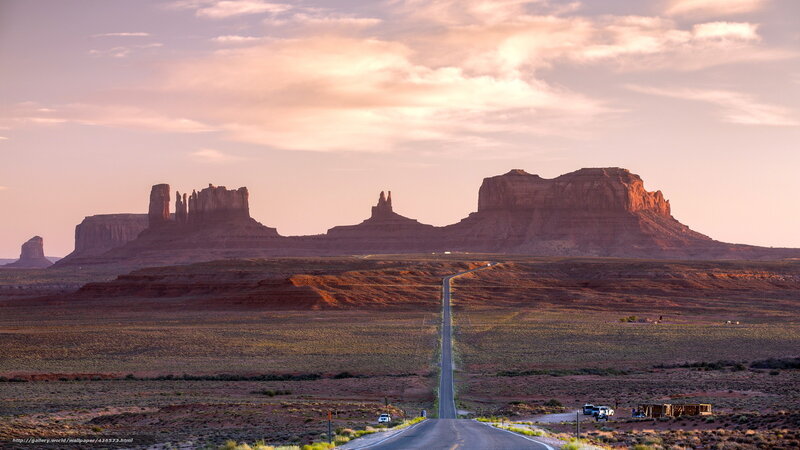 Desert road at sunset with rock formations