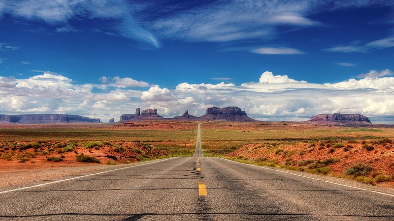 Desert road leading to mesas