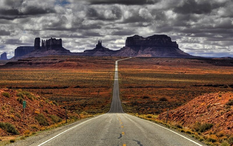 Desert road leading to rock formations