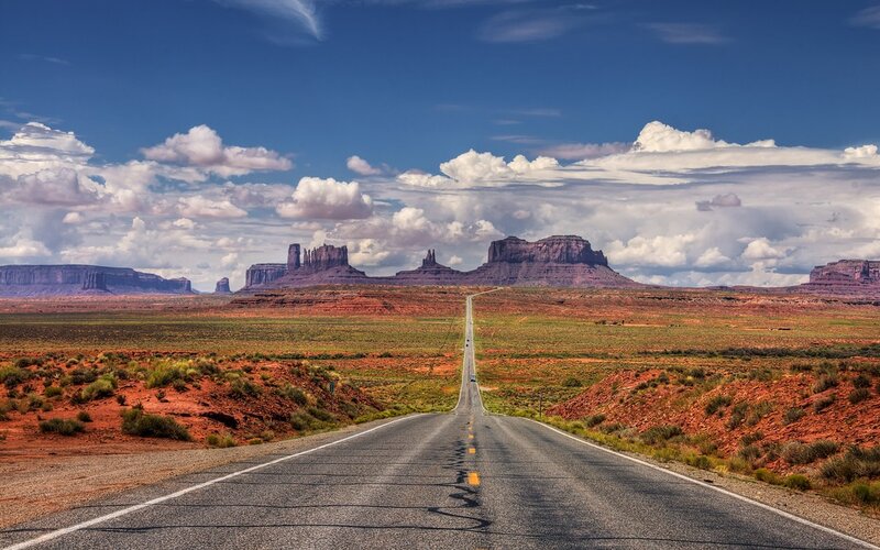 Desert road leading to rock formations