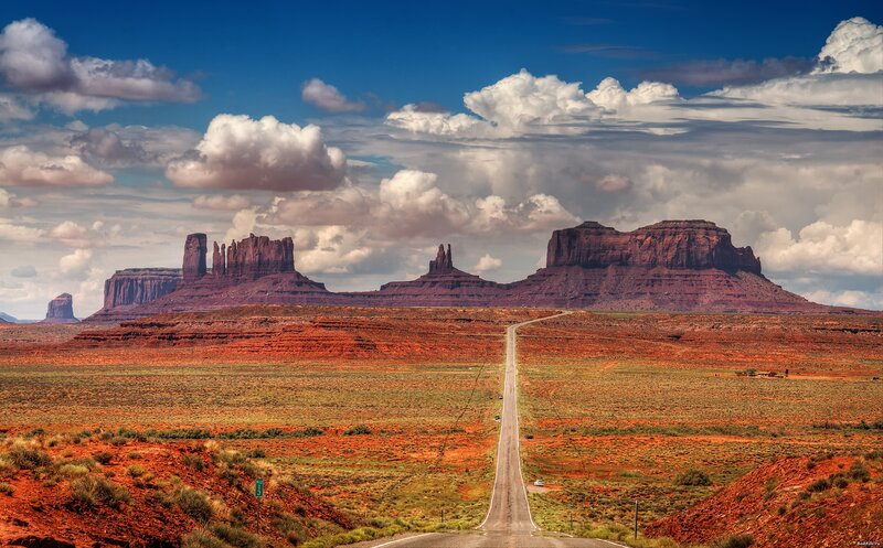 Desert road leading to rock formations