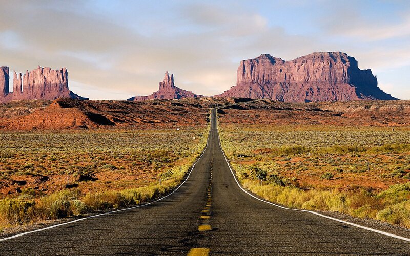 Desert road leading to rock formations
