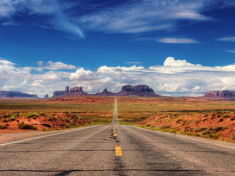 Desert road leading to rock formations