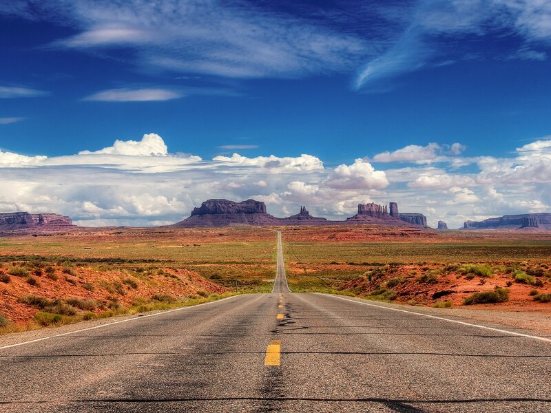 Desert road leading to rock formations