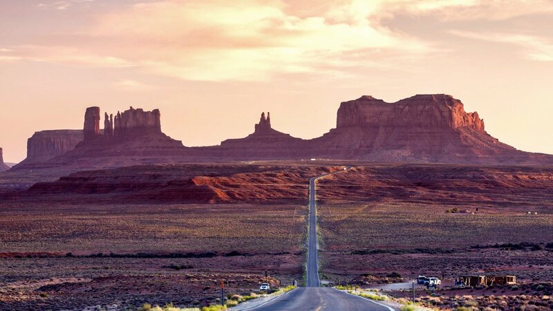 Desert road leading to rock formations
