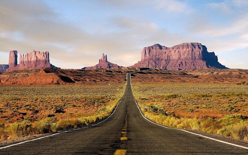 Desert road leading to rock formations