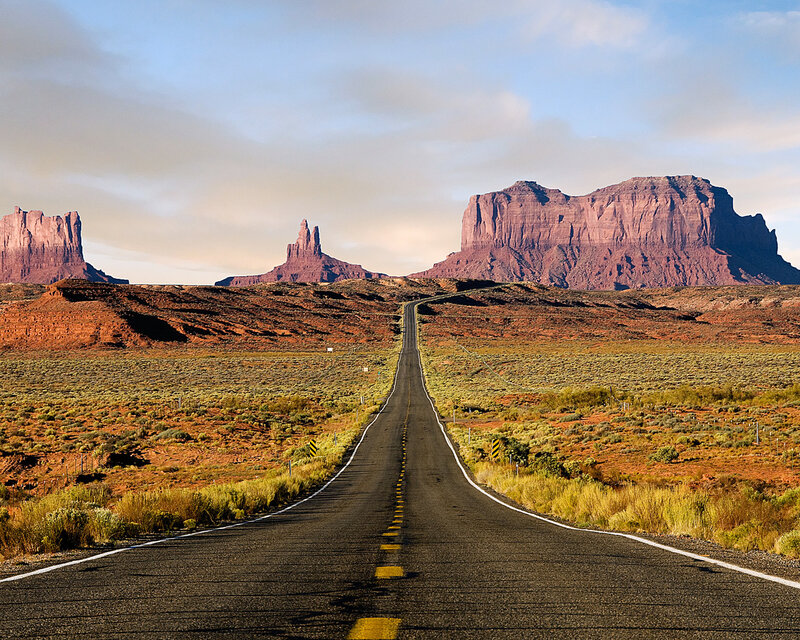 Desert road leading to rock formations