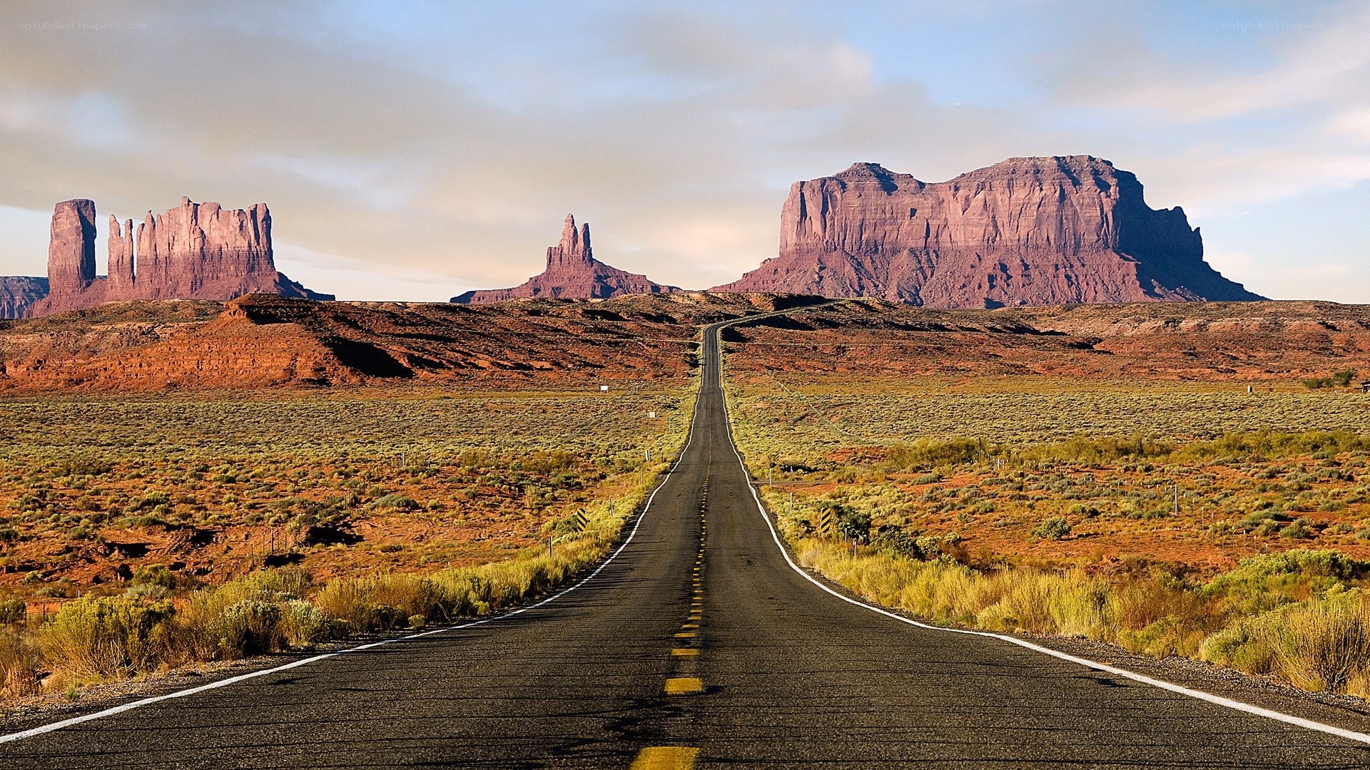 Desert road leading to rock formations