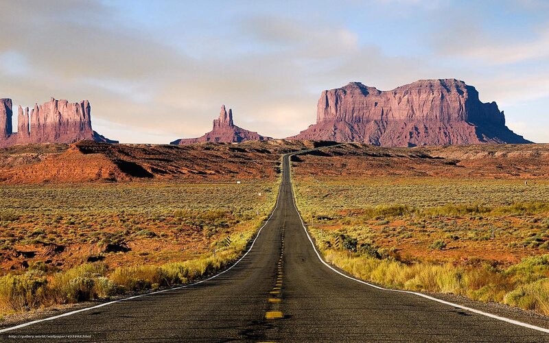 Desert road leading to rock formations