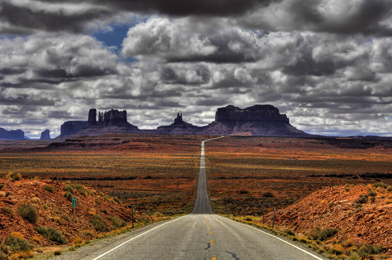 Desert road leading to rock formations