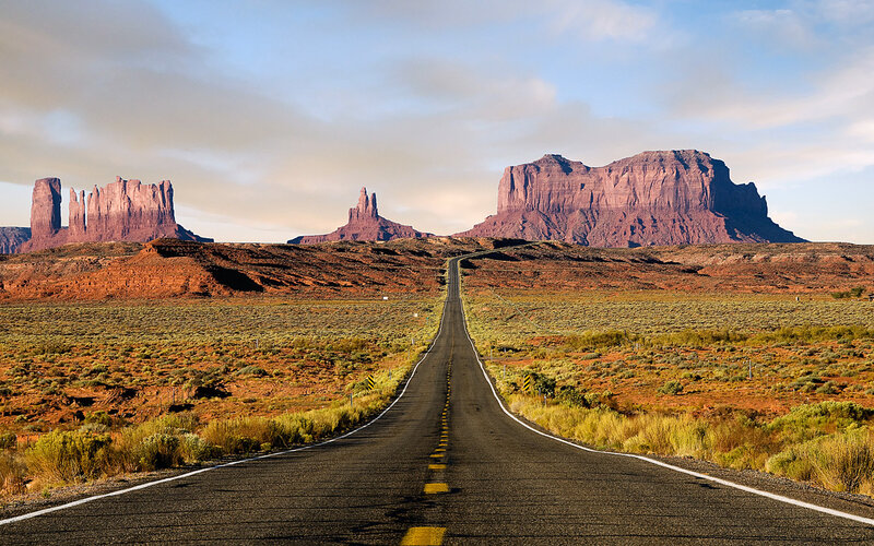 Desert road leading to rock formations