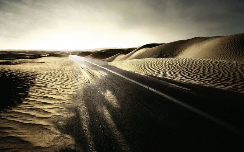Desert road through sand dunes