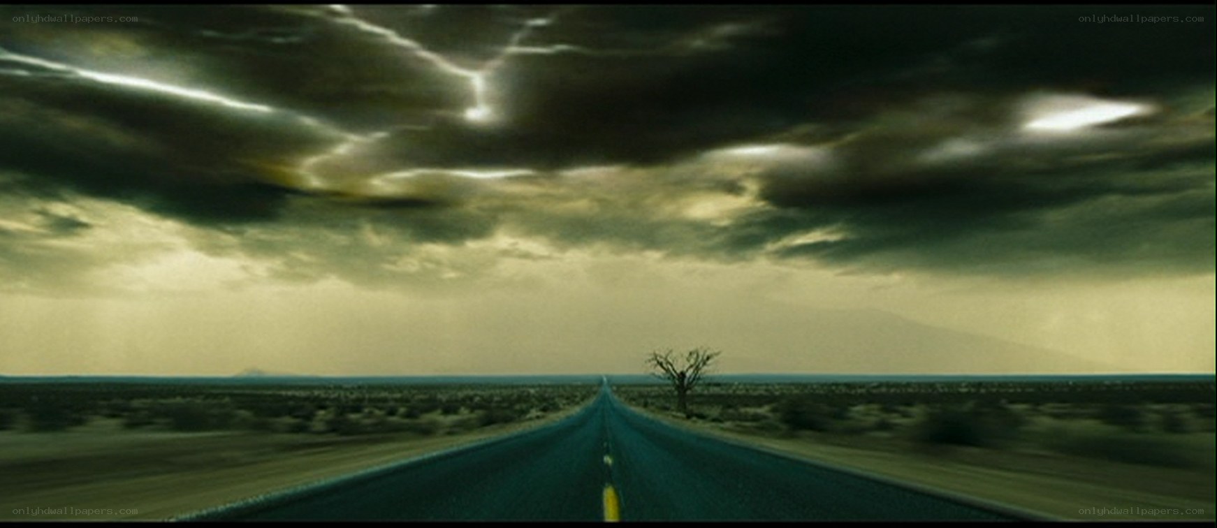 Desert road under stormy sky