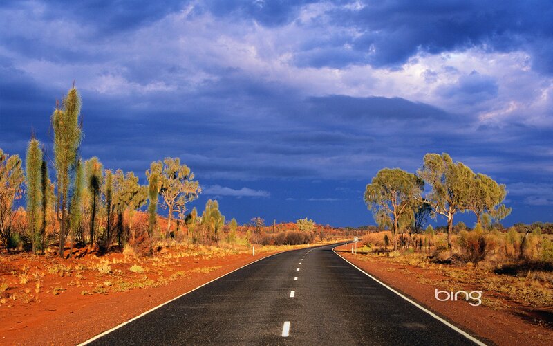 Desert road under stormy sky