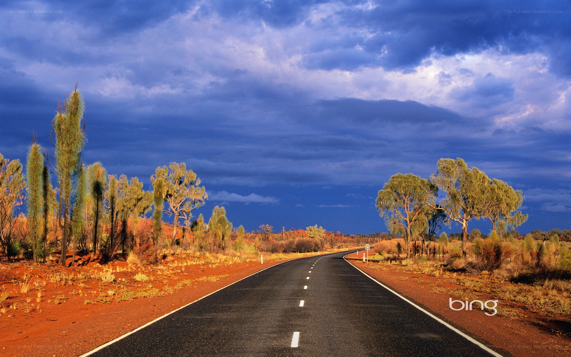 Desert road under stormy sky