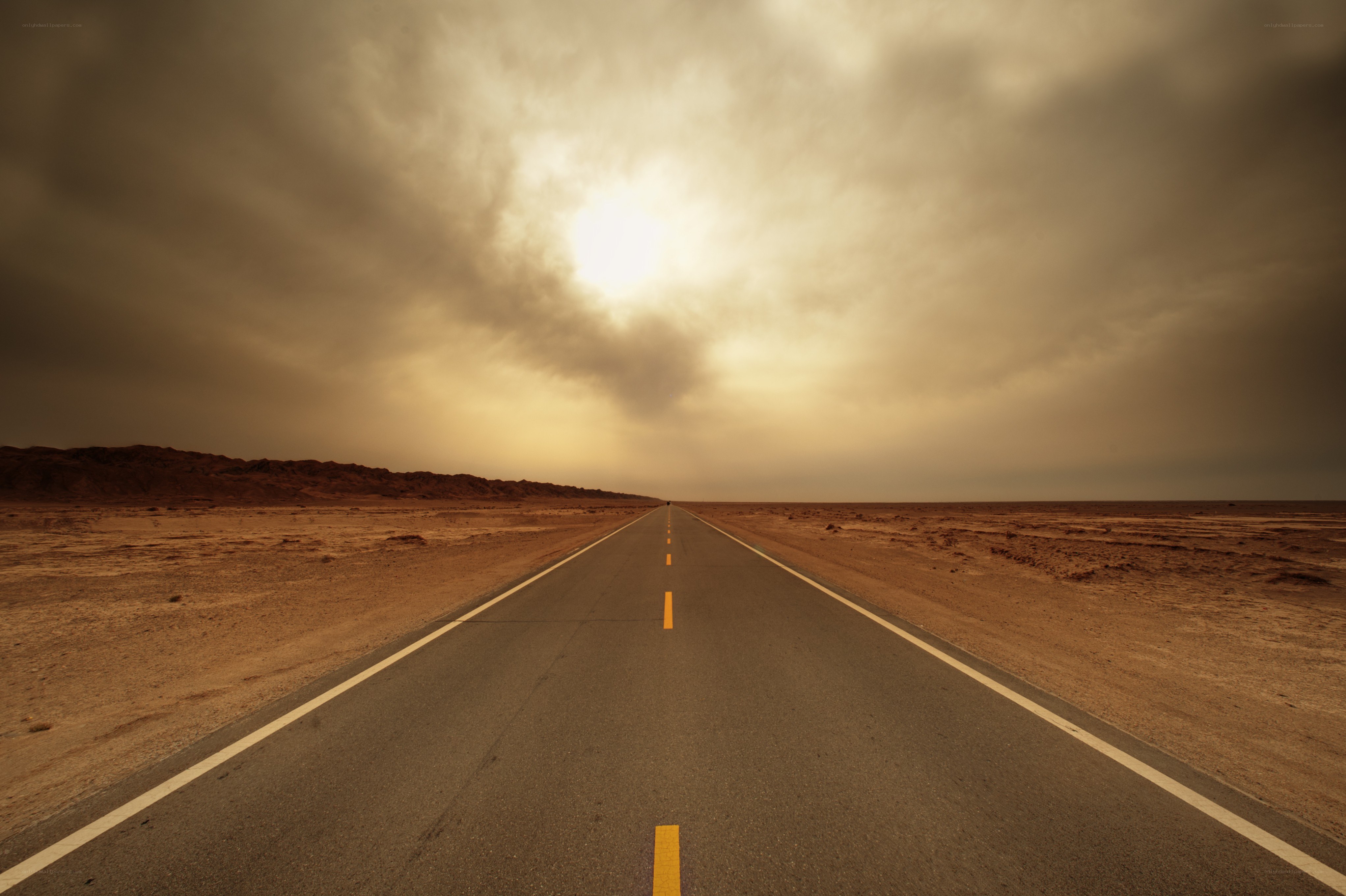 Desert road under stormy sky