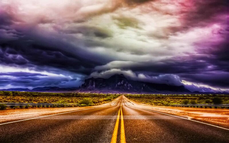 Desert road under stormy sky