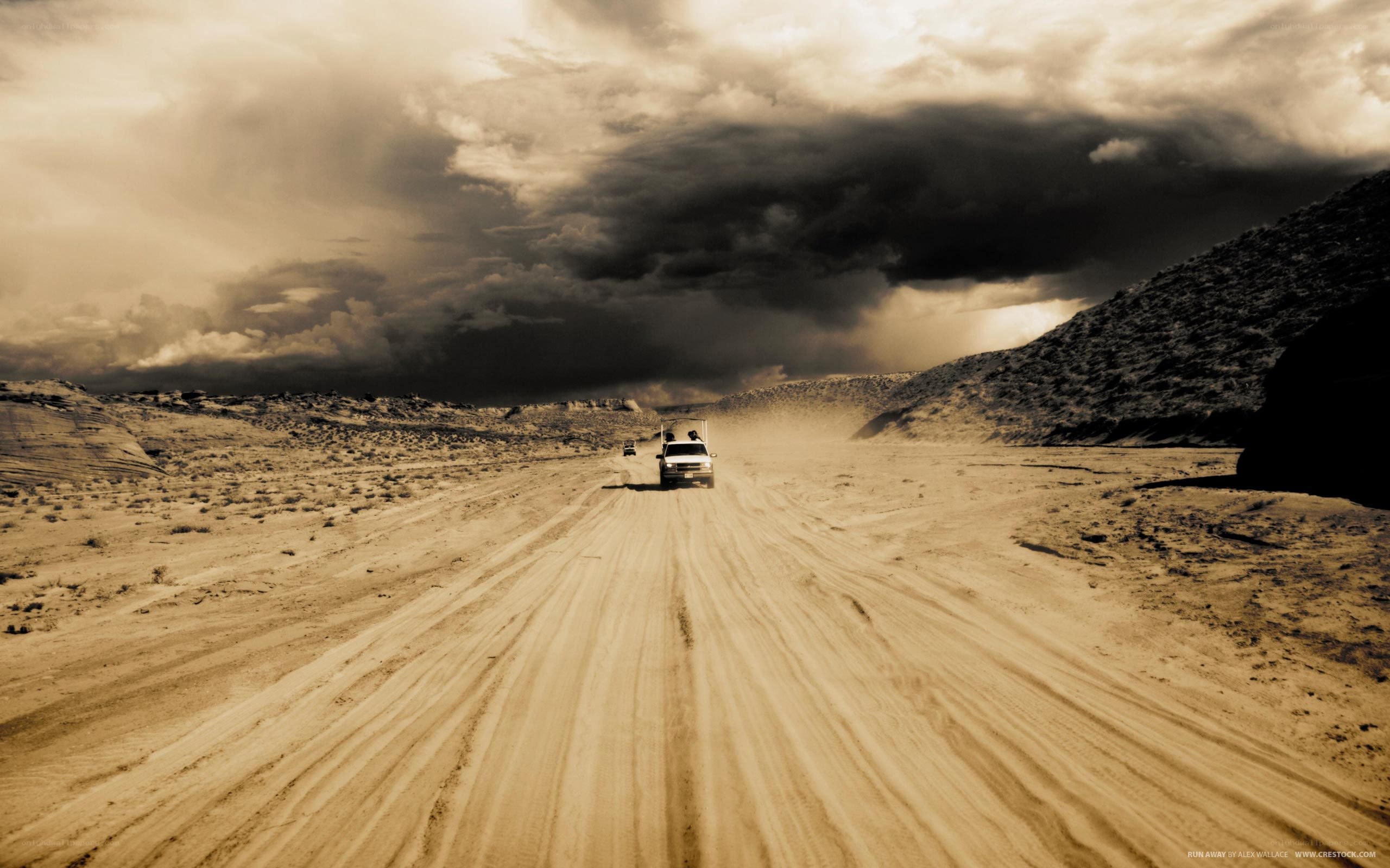 Desert road under stormy sky