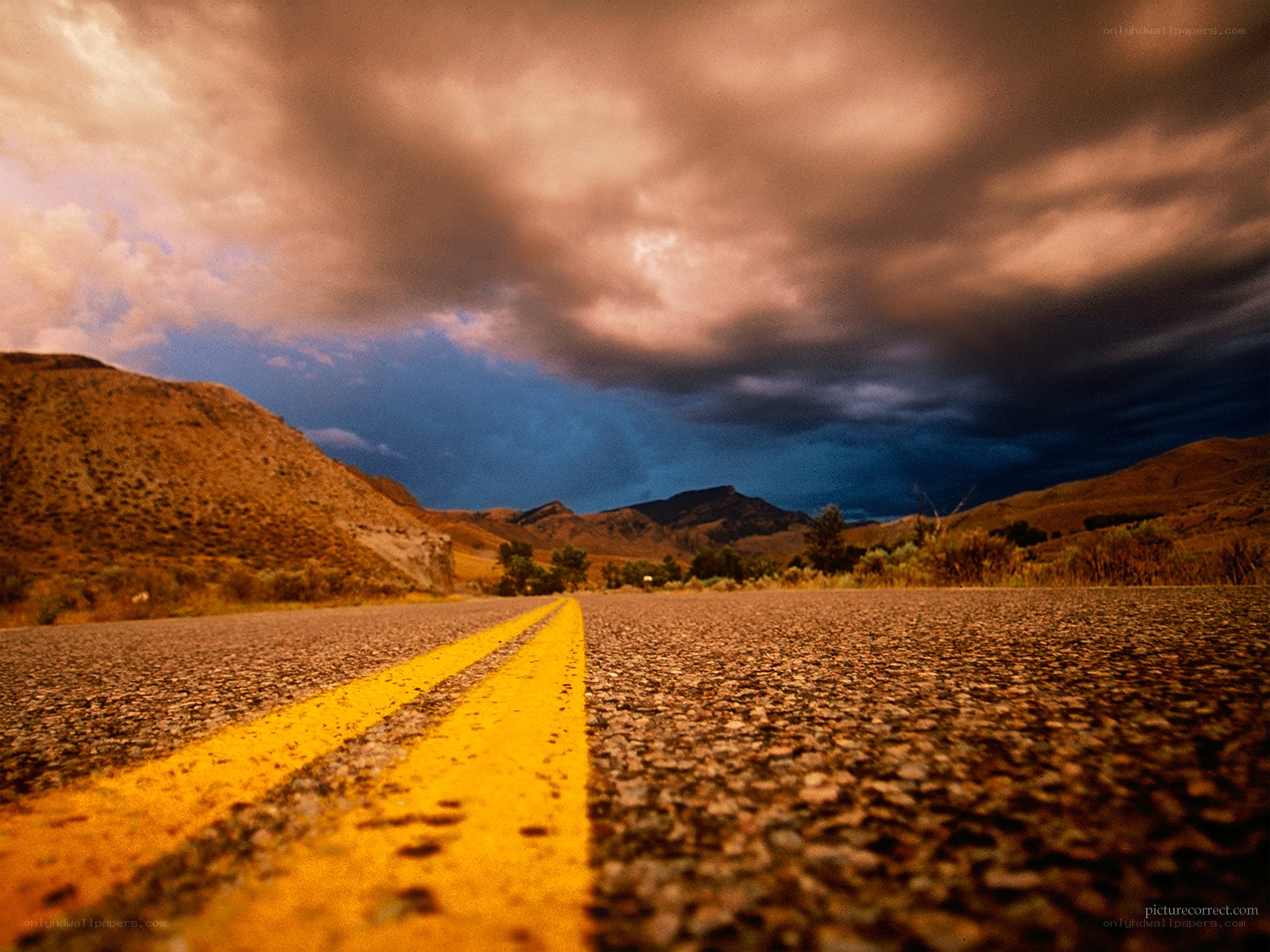 Desert road under stormy sky