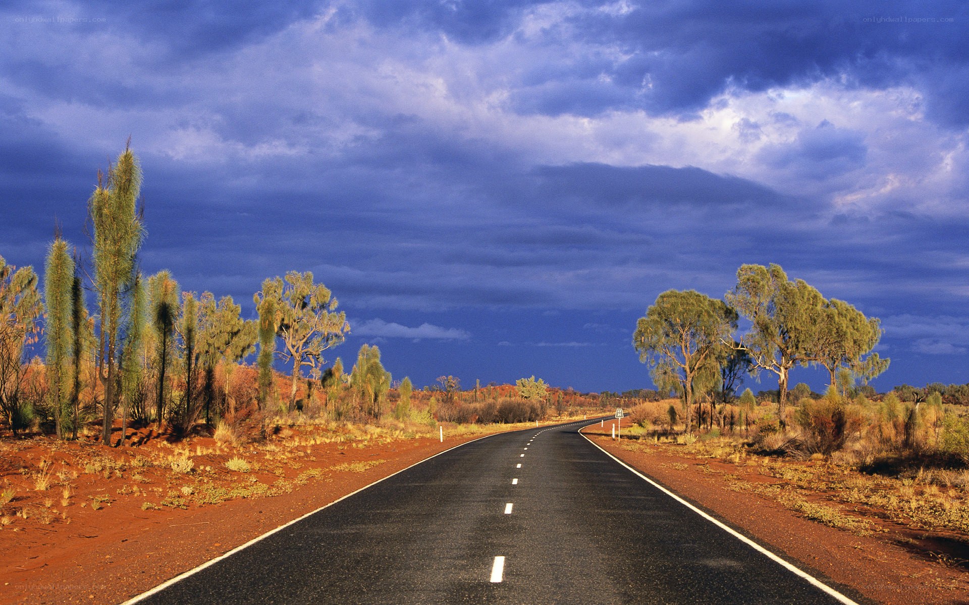 Desert road under stormy sky