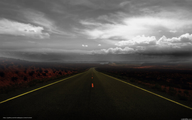 Desert road under stormy sky