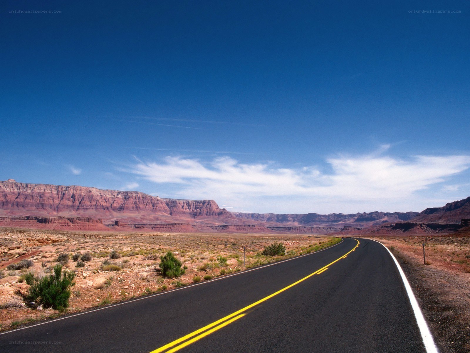 Desert road with red rock cliffs
