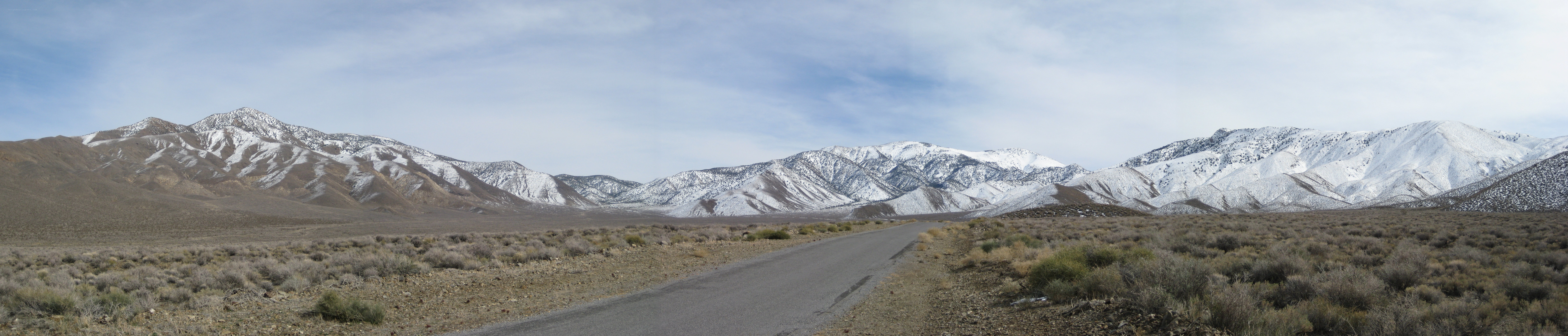 Desert road with snow-capped mountains