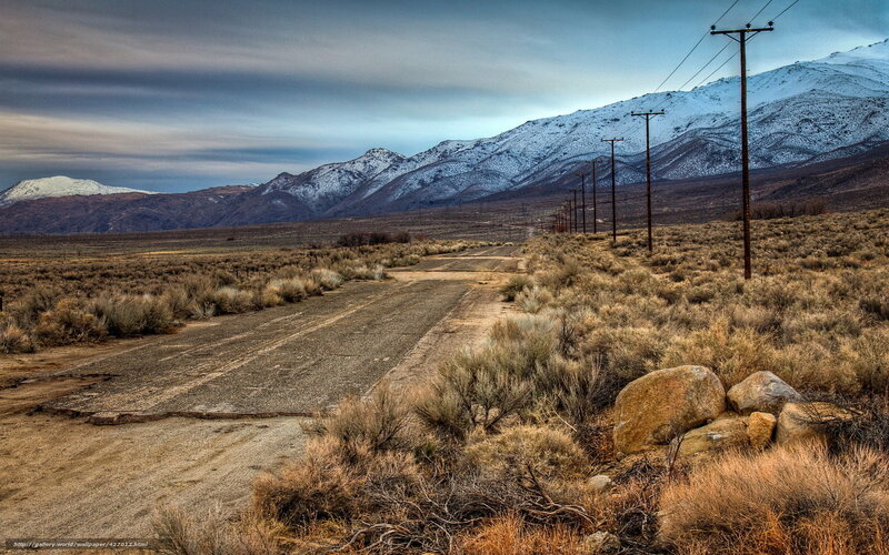 Desert road with snow-capped mountains