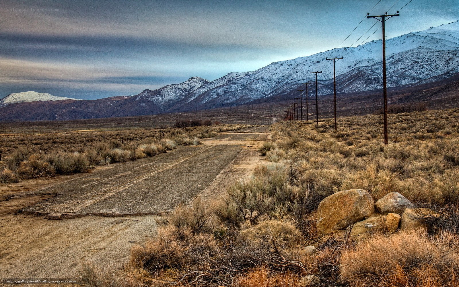 Desert road with snow-capped mountains