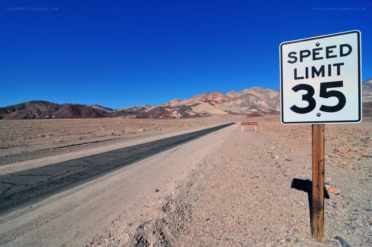 Desert road with speed limit sign