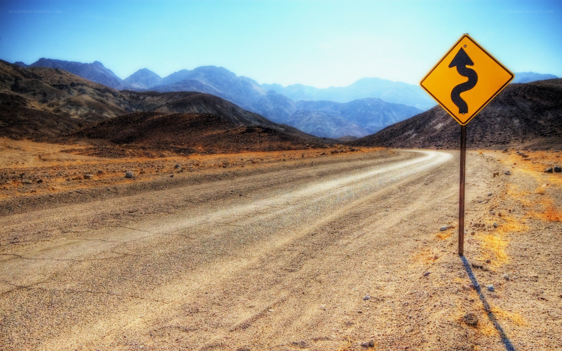 Desert road with winding sign