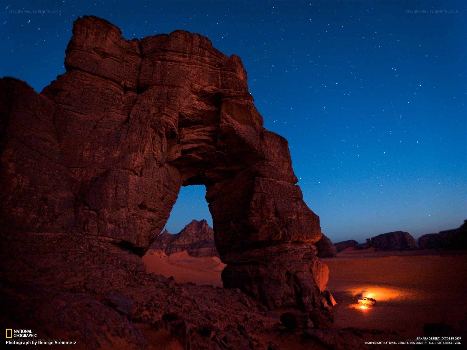 Desert rock arch under stars