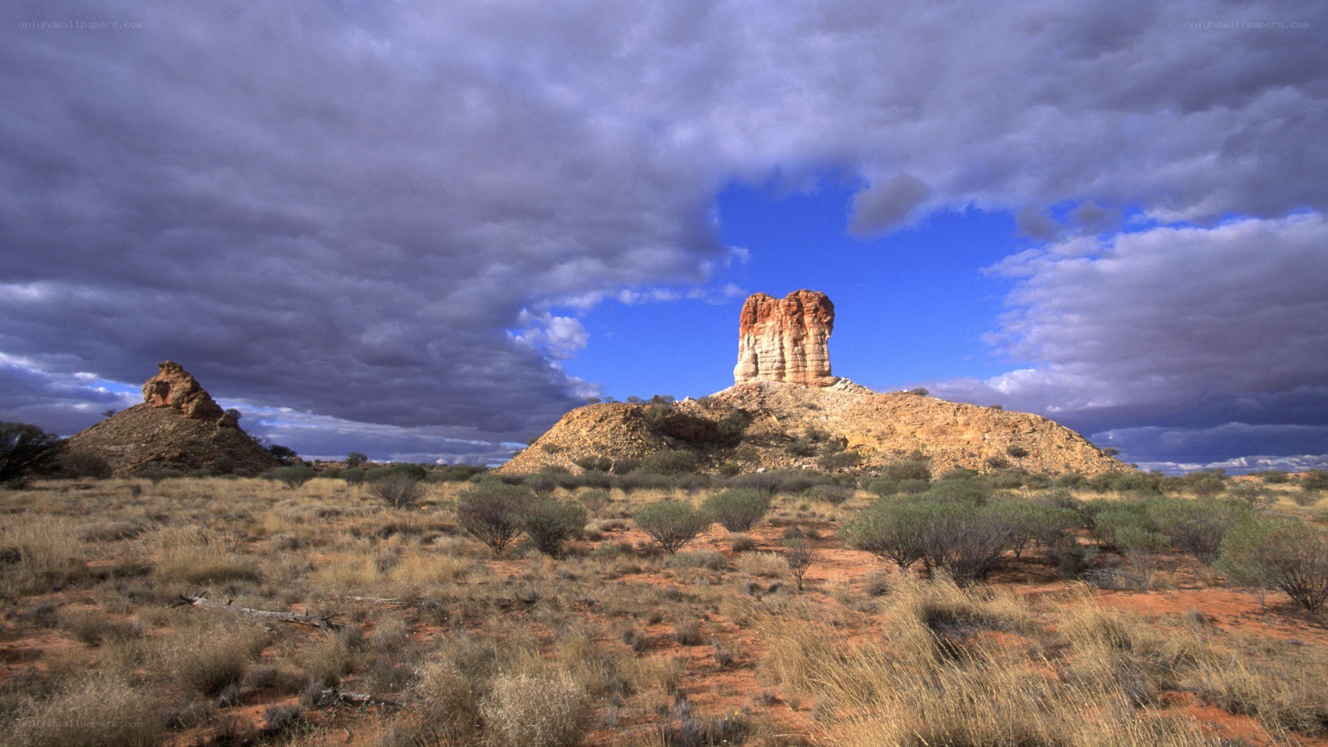 Desert rock formations under cloudy sky