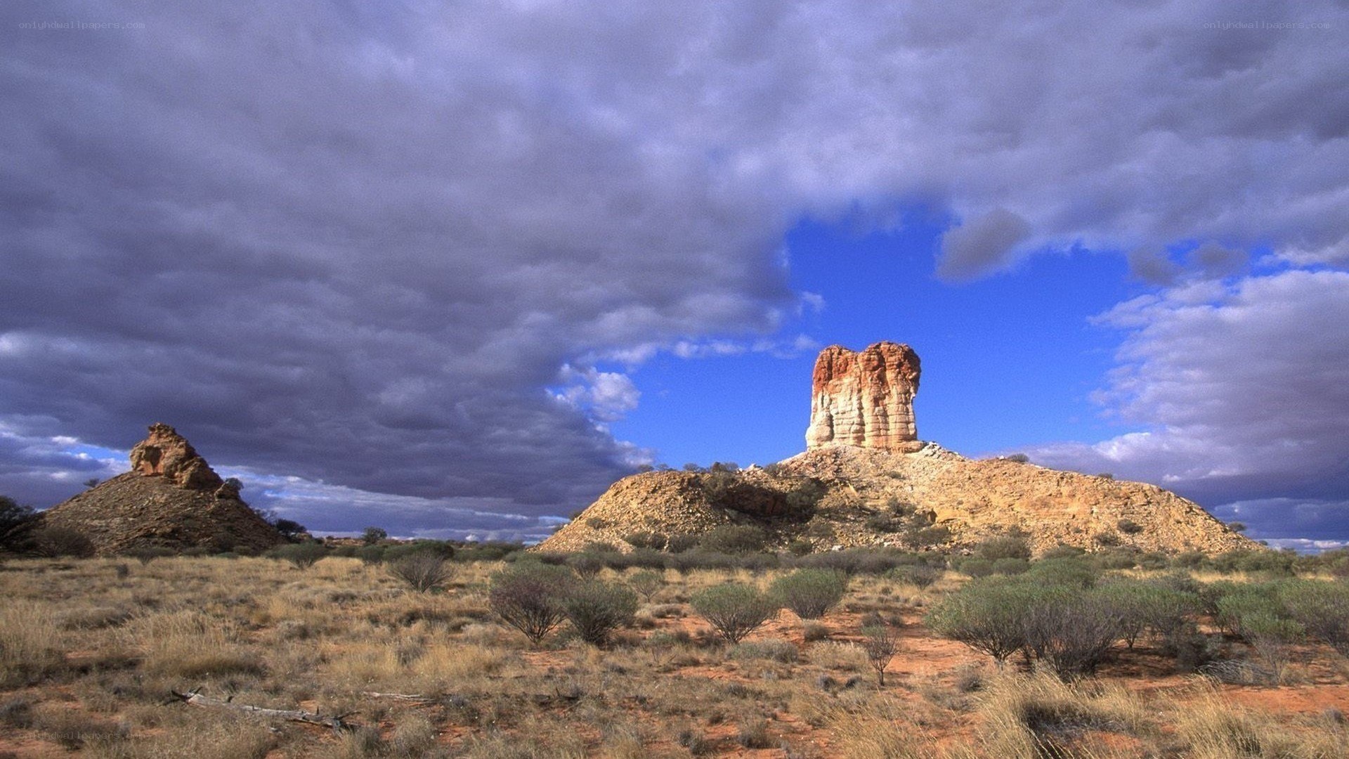 Desert rock formations under cloudy sky
