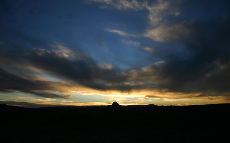 Desert sunset with silhouetted rock