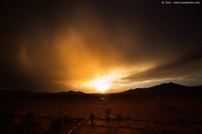 Desert sunset with traveler