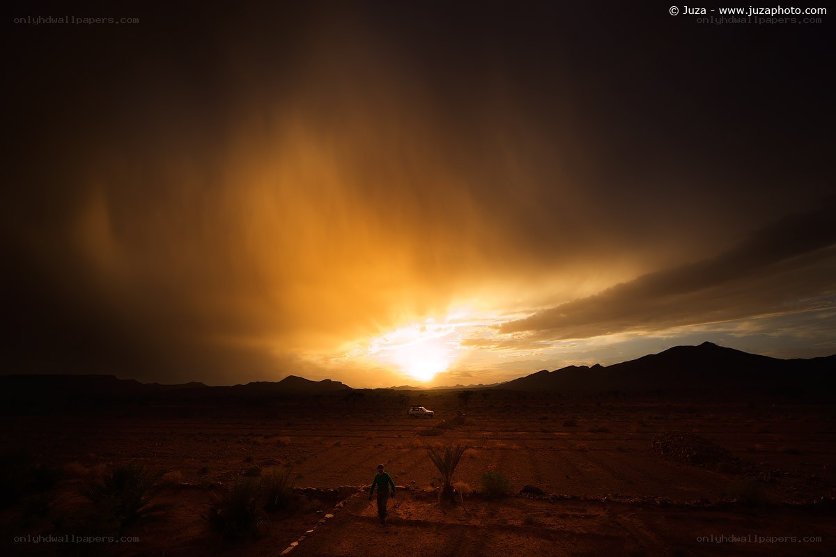 Desert sunset with traveler