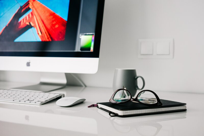 desk with computer and glasses
