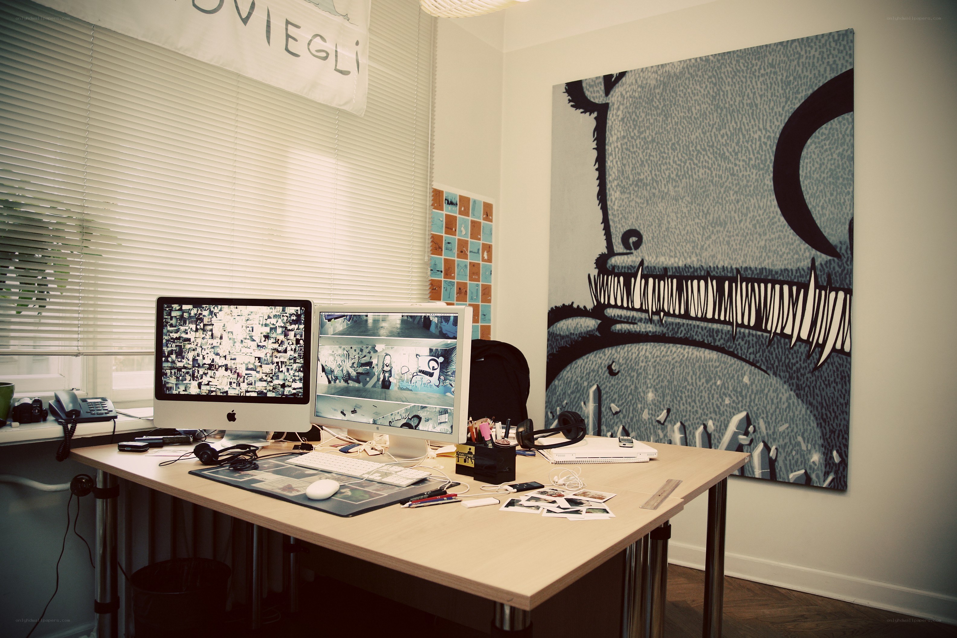 desk with dual monitors and artwork
