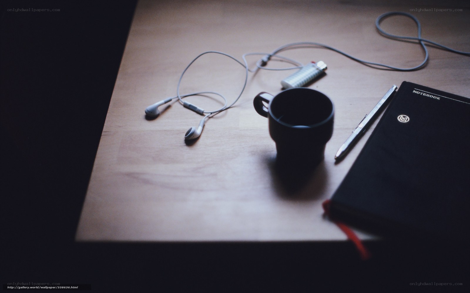 desk with notebook and earbuds