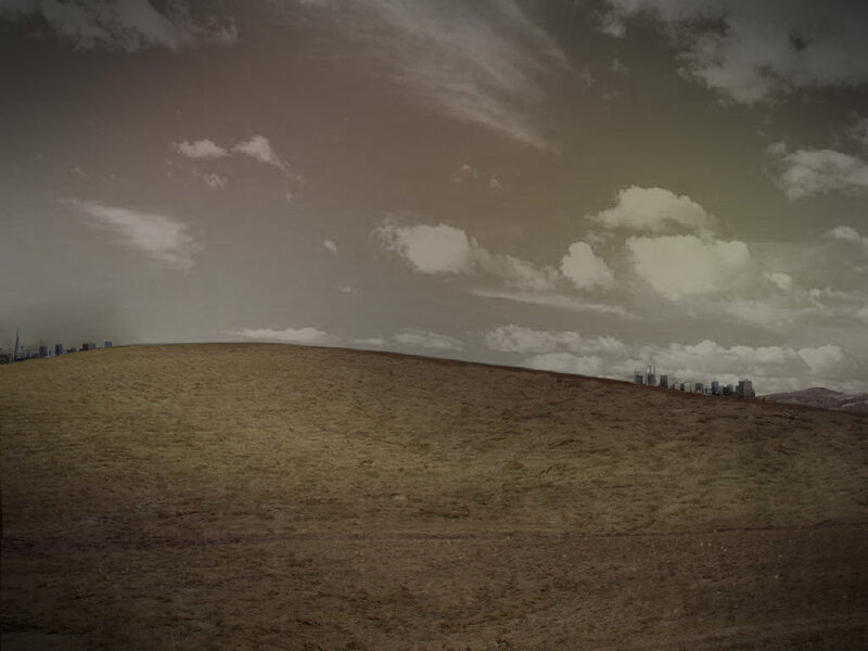 Desolate hill with city skyline
