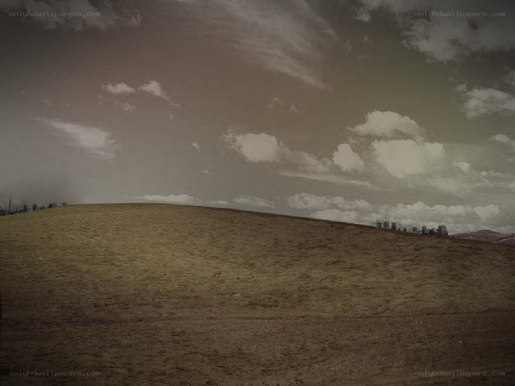 Desolate hill with city skyline