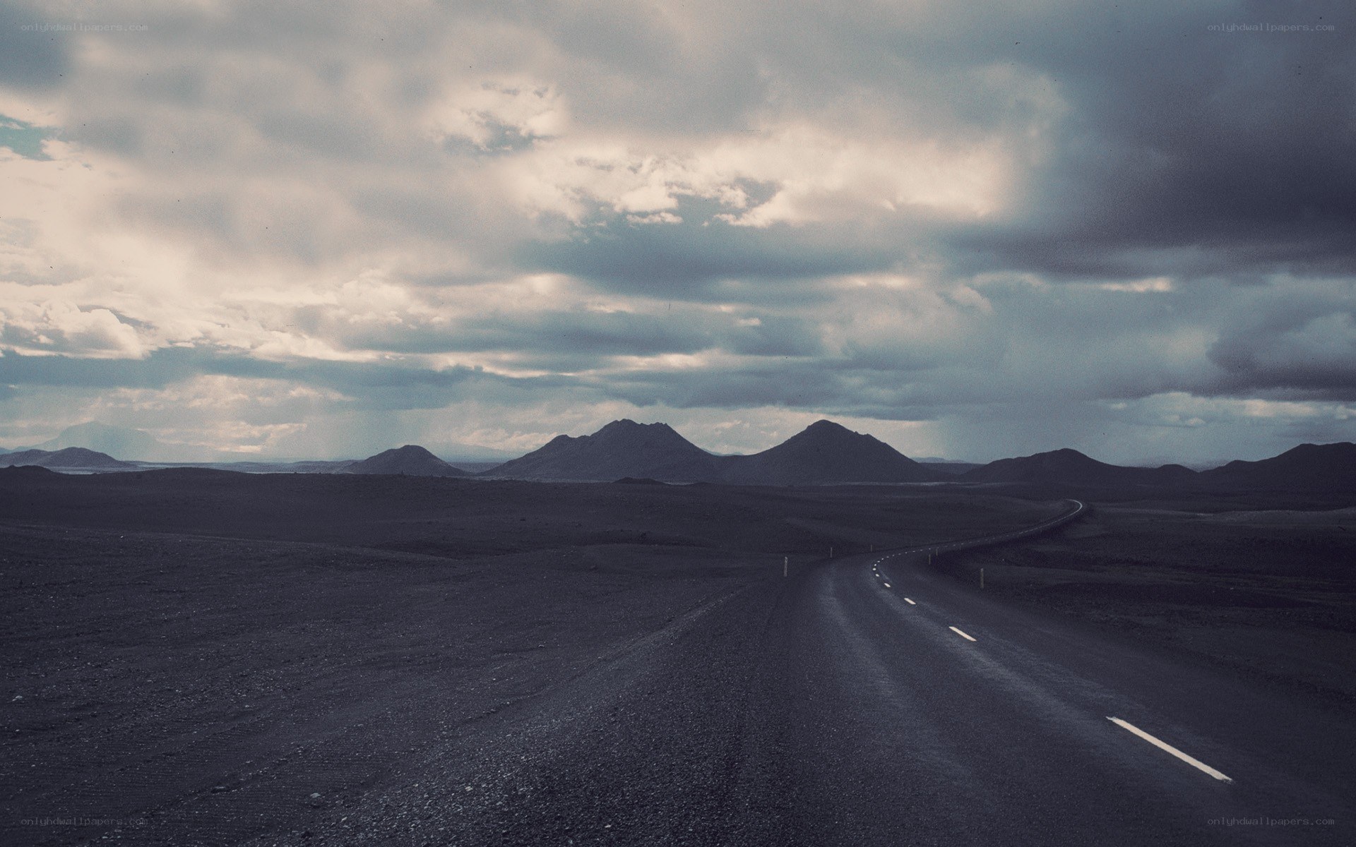 Desolate road under cloudy sky