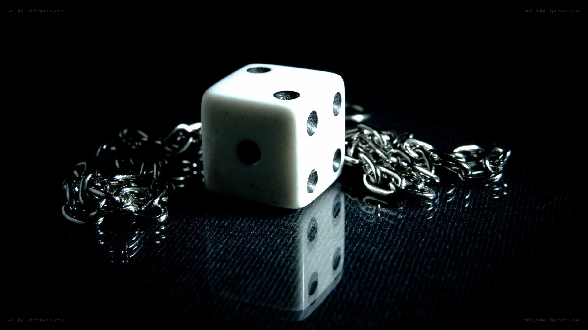 Dice and chain on dark surface