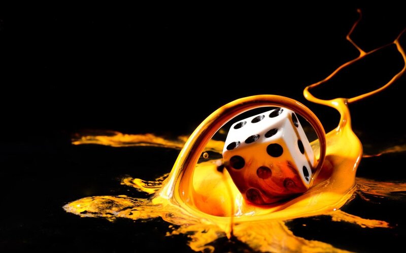 dice in golden liquid splash