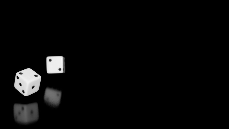 Dice rolling on black surface