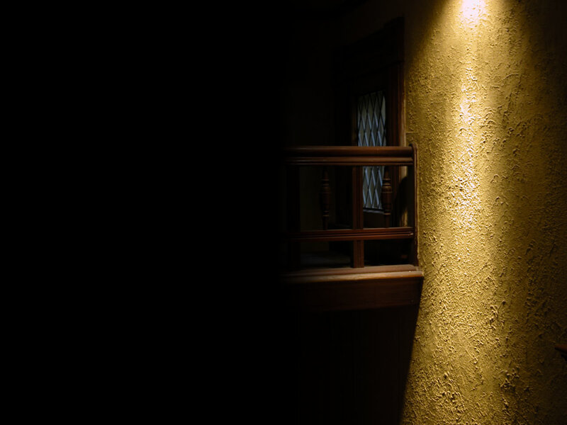 dimly lit hallway with wooden railing