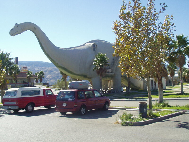 Dinosaur-shaped building in parking lot