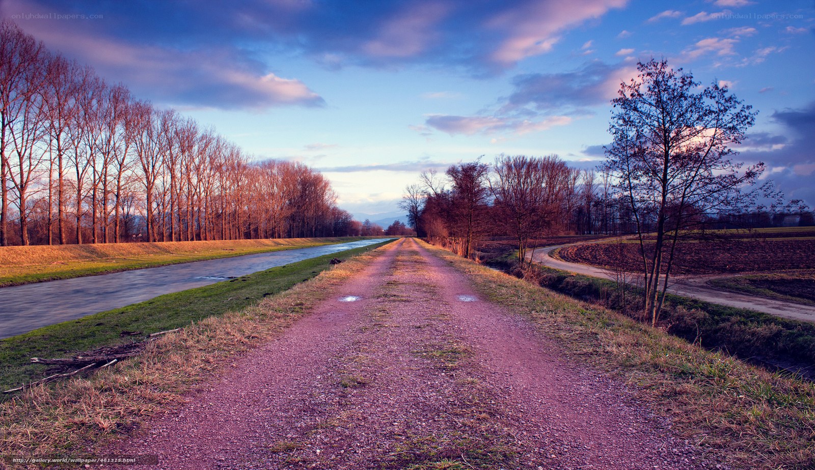 Dirt path by canal at dusk