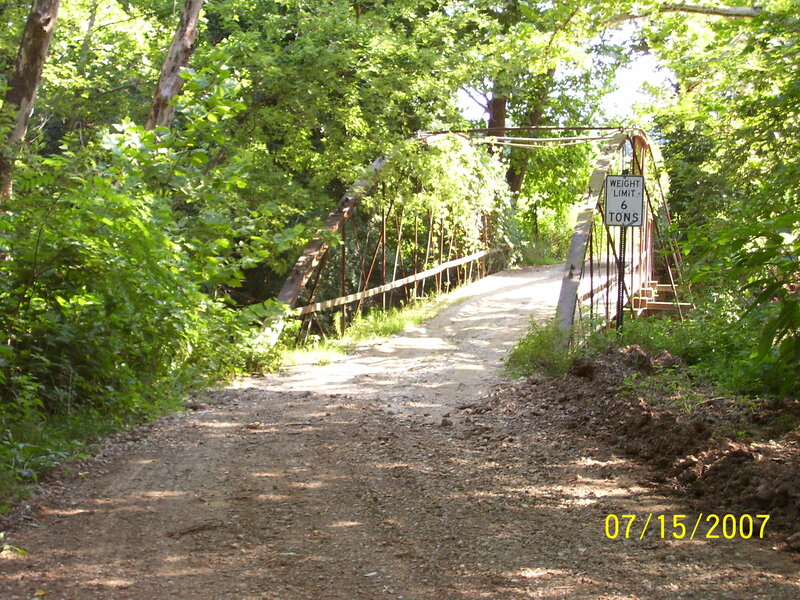 Dirt path leading to a forest bridge